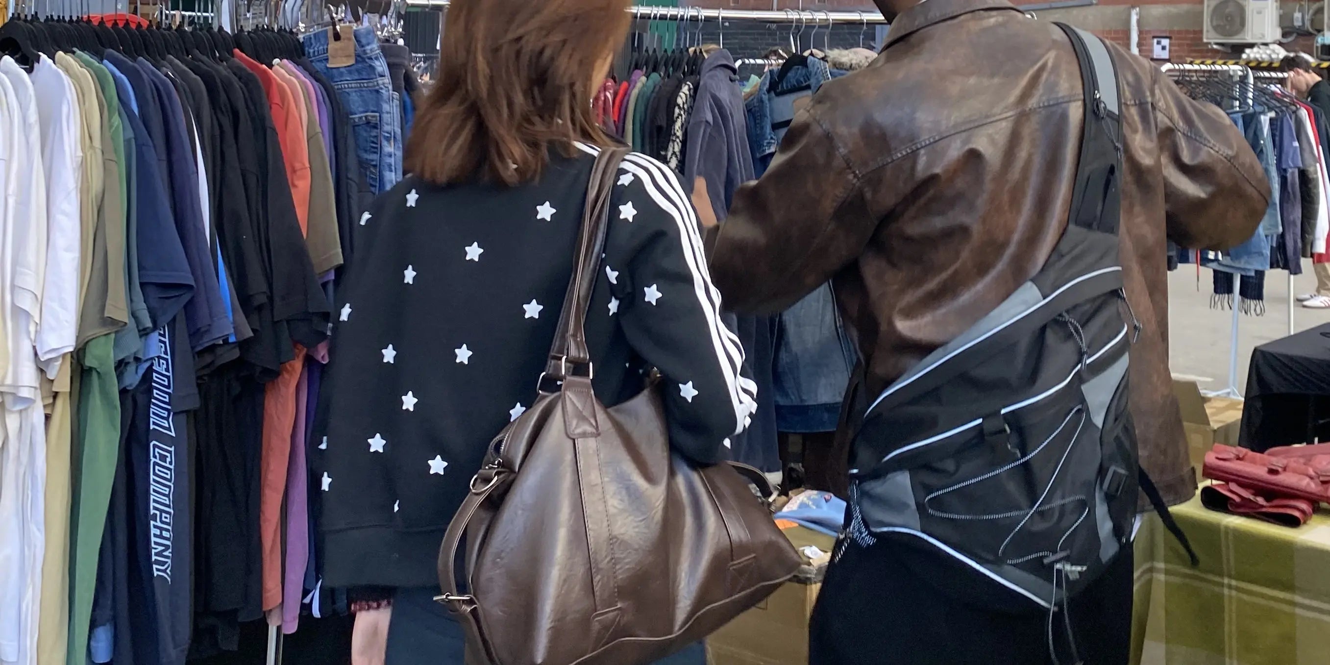 Two customers looking through some racks of vintage cardigans