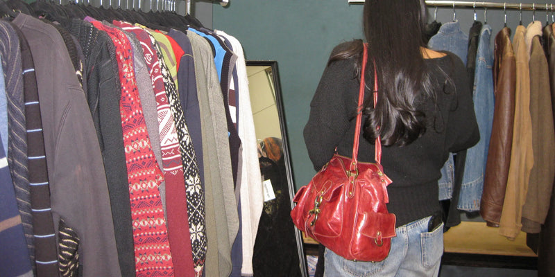 A customer standing next to a rack of vintage jumpers