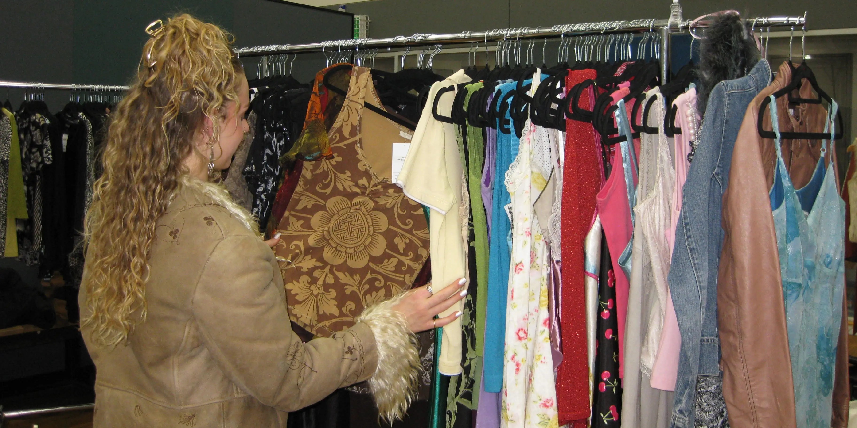 Customer looking through a rack of vintage tank tops